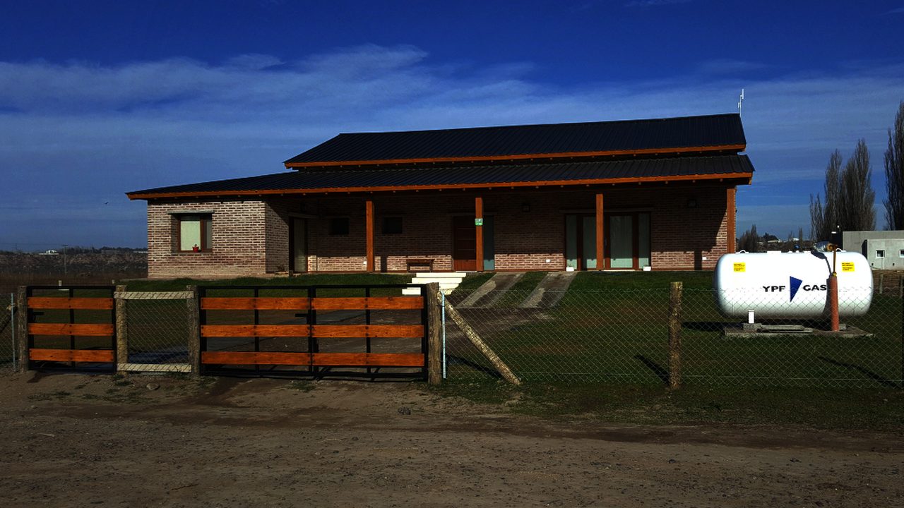 Obra terminada: vivienda de ladrillo en El Vergel, vista de frente con el portón